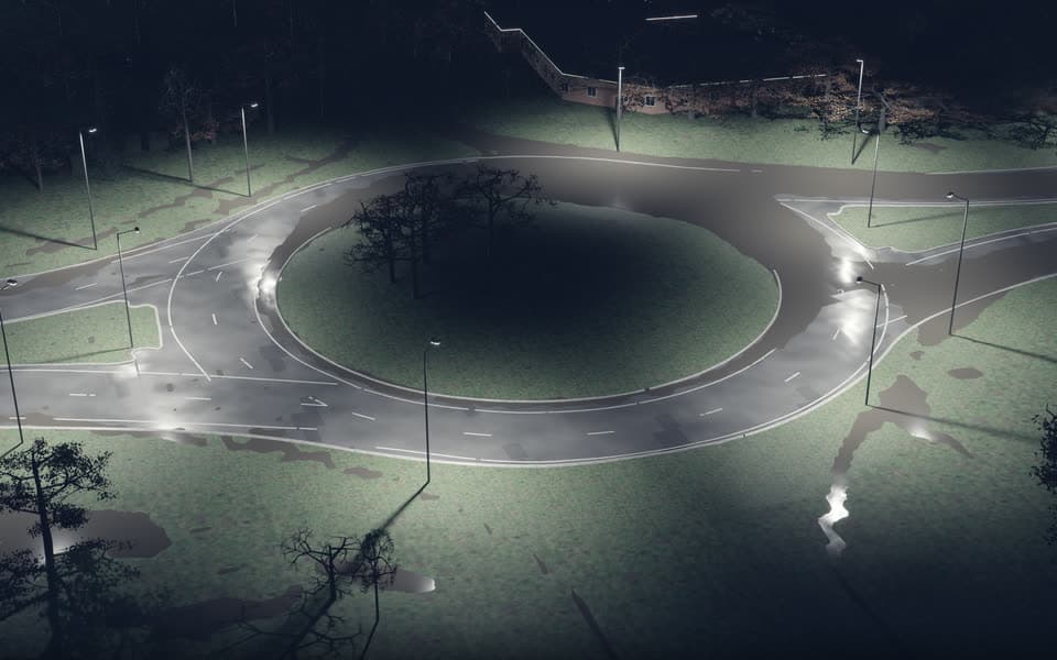 Whyke Roundabout at night in the modelled storm, path-traced in Omniverse, with water lying along the carriageway edges.